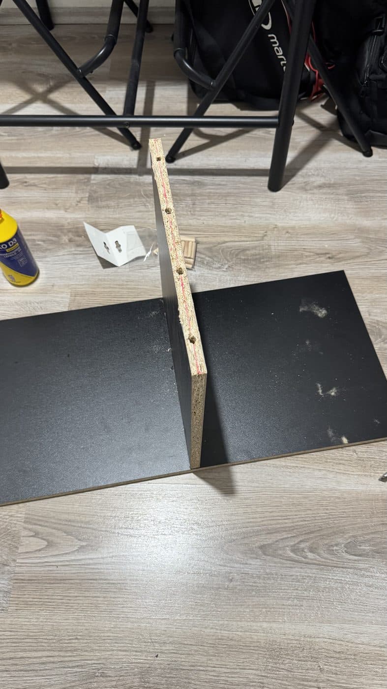 Dowels and glue laid out on the floor beside two panels.